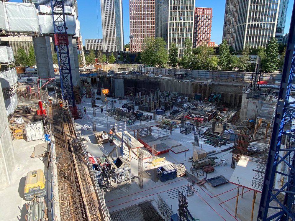 Wide view of a construction site with the surrounding city skyline